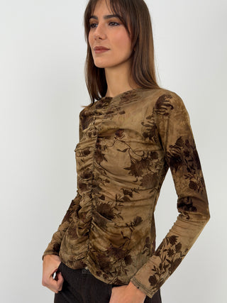 Maglia senape in tulle con fantasia floreale e dettagli in velluto. Maniche lunghe, girocollo e arricciatura frontale.