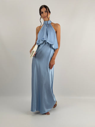 Abito azzurro polvere in tessuto satinato con collo halter e top con balza arricciata. Spalline sottili e regolabili.