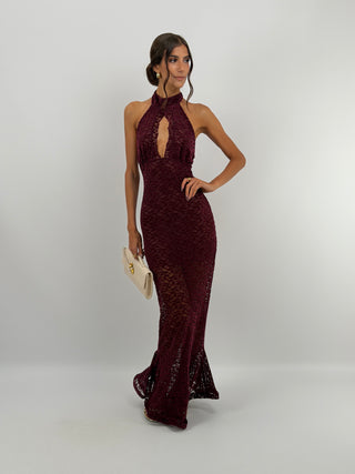 Abito in Pizzo Bordeaux con Volant - Abito lungo bordeaux aderente in pizzo, con collo halter e bottoncini sul retro. Cut out frontale a goccia, gonna aderente con volant ampio sul fondo, schiena scoperta. | Paloma Store