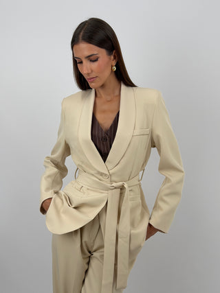 Completo Blazer con Cintura e Pantalone Beige - Completo beige, composto da blazer con cintura, collo a scialle e fodera interna, e pantalone a palazzo con tasche laterali, chiusura con zip e bottone ed elastico in vita sul retro. | Paloma Store