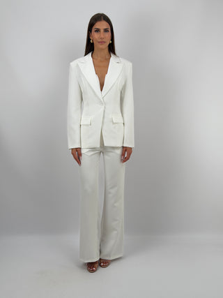Completo Giacca Monopetto e Pantalone Bianco - Completo bianco, composto da giacca monopetto sfiancata con rever e fodera interna, e pantalone flare con elastico in vita sul retro, chiusura con zip e bottone e tasche laterali. | Paloma Store