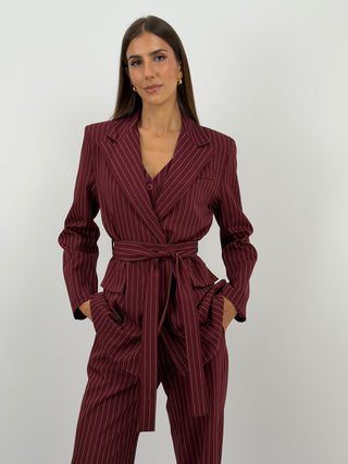 Completo Giacca con Cintura e Pantalone Gessato Bordeaux - Completo bordeaux in tessuto gessato, composto da blazer doppiopetto con cintura in vita e tasche con patta, e pantalone palazzo con elastico in vita, tasche laterali e chiusura con zip e bottone. Gilet abbinato acquistabile separatamente. | Paloma Store