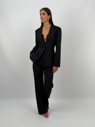 Completo Giacca Monopetto e Pantalone Nero - Completo nero, composto da giacca monopetto sfiancata con rever e fodera interna, e pantalone flare con elastico in vita sul retro, chiusura con zip e bottone e tasche laterali. | Paloma Store