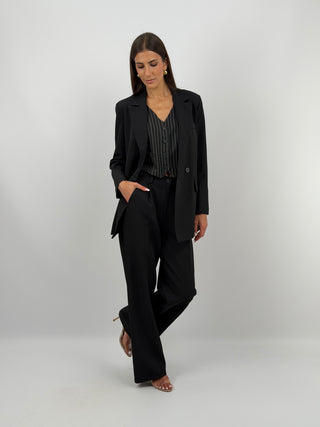 Completo Giacca Doppiopetto e Pantalone Nero - Completo nero, composto da giacca over doppiopetto con rever e fodera interna, e pantalone a palazzo con elastico in vita sul retro, chiusura con zip e bottone e tasche laterali. | Paloma Store