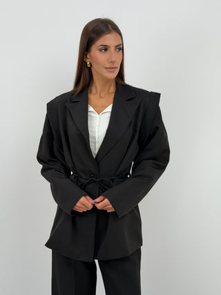 Tailleur con Spalle Strutturate Nero - Completo tailleur nero con blazer dalle spalle strutturate, maniche ampie, cinturina in vita e fodera interna. Pantalone a palazzo con passanti per cintura, chiusura con zip e bottone ed elastico in vita. | Paloma Store