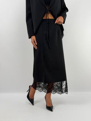 Gonna Nera con Pizzo - Gonna midi nera in tessuto strutturato e liscio. Design avvolgente con inserti in pizzo e spacco frontale. Zip laterale nascosta. | Paloma Store