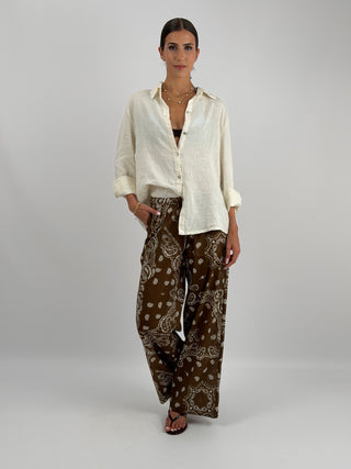 Pantalone Palazzo con Fantasia Bandana Marrone - Pantalone lungo a palazzo in fantasia bandana a contrasto. Presenta laccio regolabile in vita, fodera interna, tasche laterali e tasca sul retro. | Paloma Store