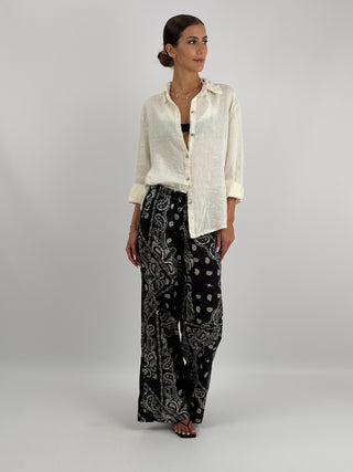 Pantalone Palazzo con Fantasia Bandana Nero - Pantalone lungo a palazzo in fantasia bandana a contrasto. Presenta laccio regolabile in vita, fodera interna, tasche laterali e tasca sul retro. | Paloma Store