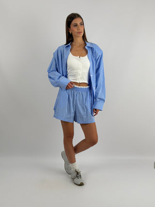 Completo Camicia e Shorts a Quadri Azzurro - Set coordinato azzurro e bianco a quadretti, con camicia e shorts. Camicia over con spalline, shorts con elastico in vita e tasche laterali. | Paloma Store