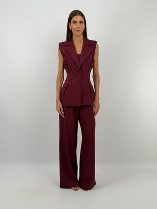 Completo Gessato con Gilet Bordeaux - Set coordinato bordeaux in tessuto gessato, composto da gilet smanicato con chiusura monopetto, pinces sul davanti, spalline imbottite, fodera interna e revers, e pantalone a palazzo con elastico in vita sul retro, tasche laterali, chiusura con zip e bottone e passanti per cintura. | Paloma Store