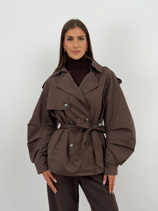 Trench con Cintura Marrone - Trench corto marrone con cintura in vita, chiusura a doppiopetto, tasche laterali e fodera trapuntata all'interno. | Paloma Store